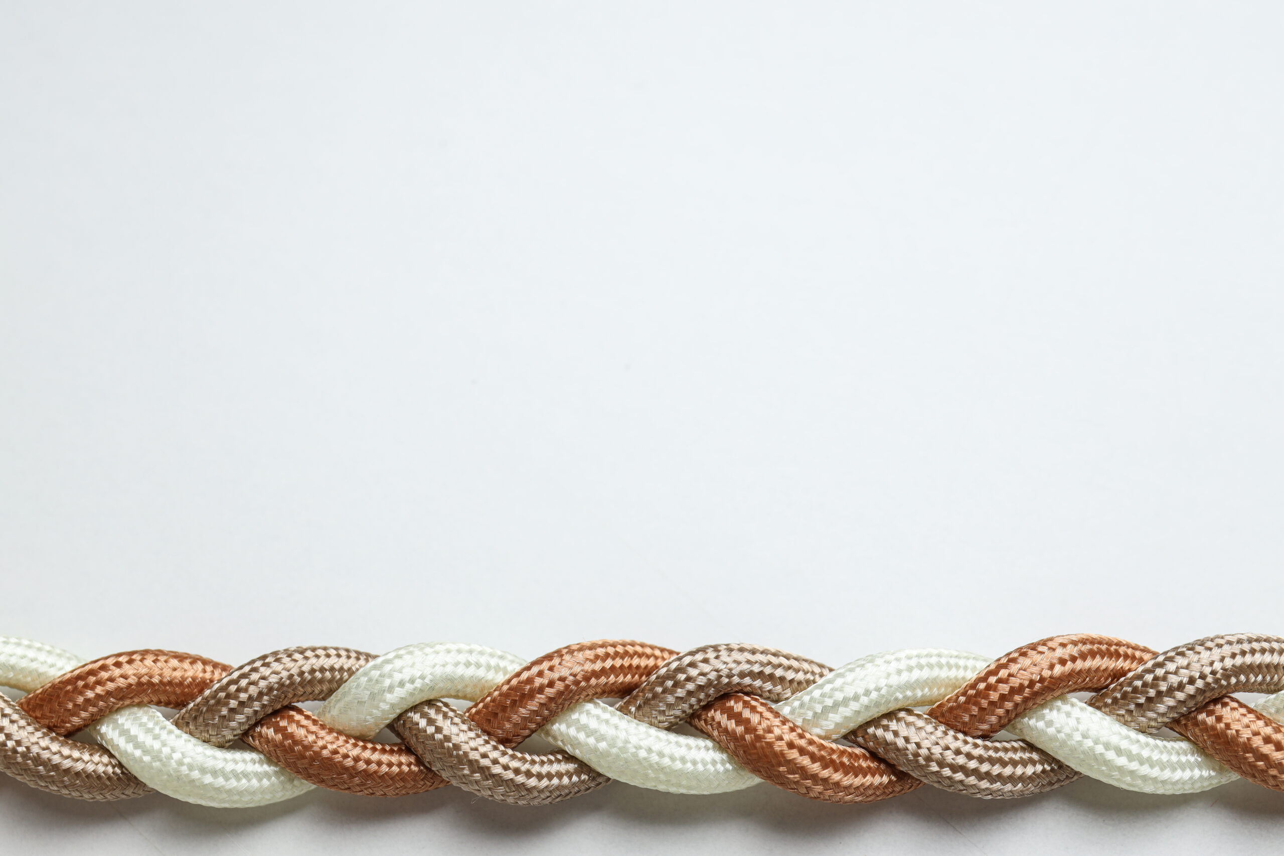 Braided multicolored ropes on a white background. Concept of uni